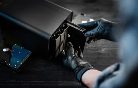 System Administrator With Gloved Hands Inserting An Hdd Hard Disk Drive Into  写真素材