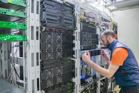 System administrator installs a new server in a modern data center. Specialis 库存照片