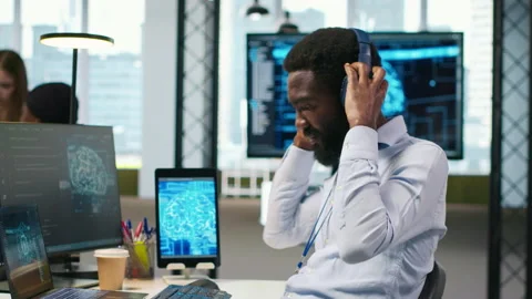 System administrator at office desk develops software using AI, listening music Stock Footage 313164307