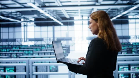 System administrator in server farm using laptop to patch network issues Video stock 277653468