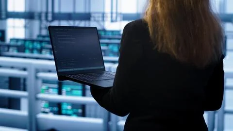 System administrator in server farm using laptop to patch network issues Stock Photos
