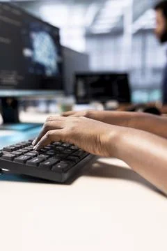 System administrator in server farm using AI systems, typing on keyboard Stock Photos