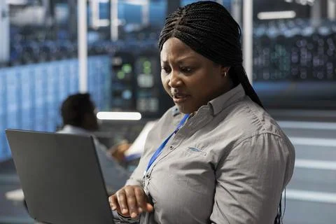 System administrator in server room doing data backup Stockfoto's