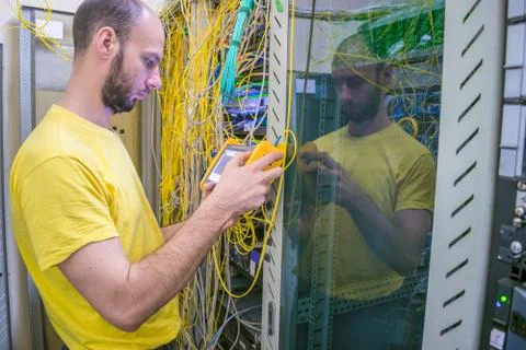 The system administrator is testing the network with a reflectometer.  The ma Stock Photos