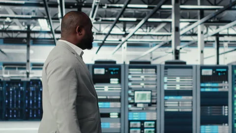 System administrator walking in data center with rigs doing backups Stock Footage 311833157