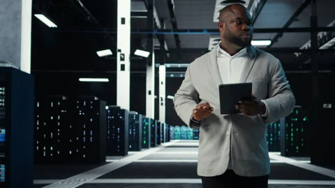 System administrator walking in data center analyzing infrastructure performance Stock Footage 311897777
