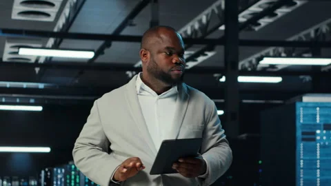 System administrator walking in data center analyzing infrastructure performance Stock Footage 311898402