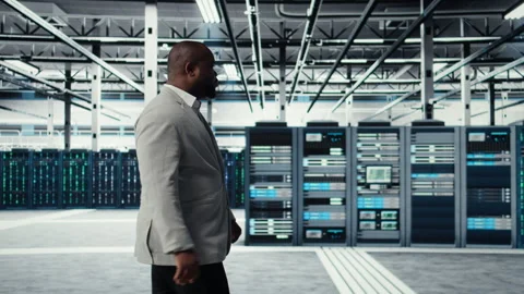 System administrator walking in data center with rigs doing backups Stock Footage 311898686