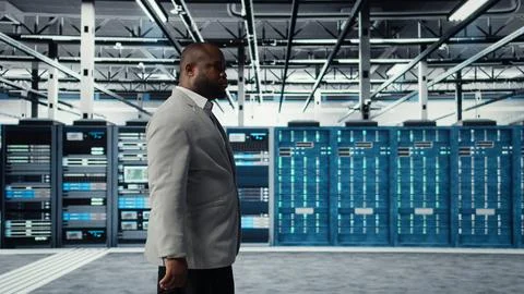 System administrator walking in data center with rigs doing backups Stock Photos