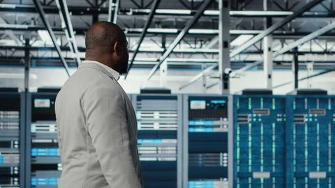 System administrator walking in data center with rigs doing backups Stock Photos