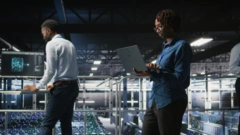 System administrators on data center platform analyzing performance outputs Stock Photos