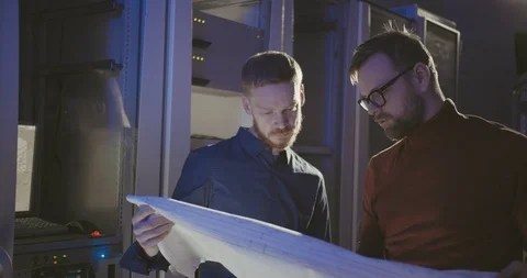 System administrators discuss fragments of server rack scheme Stock Footage 107919755