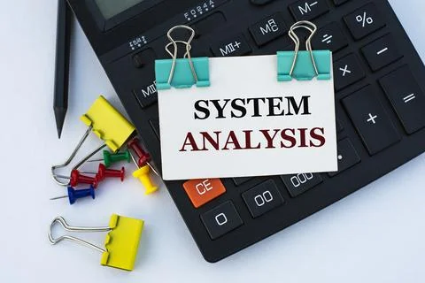 SYSTEM ANALYSIS - words on a white sheet with clips on a white background wit Stock Photos
