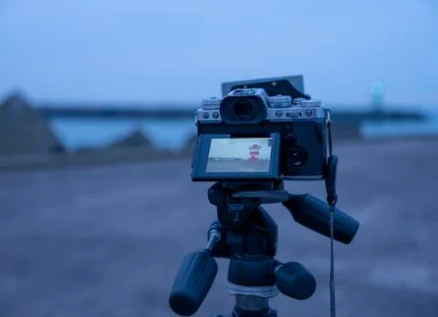 A system camera on a tripod with ND filter on it, during the blue hour on the Stock Photos