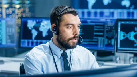 System Control Room Dispatcher Talks into Headset. He Controls Correct Work Stock Photos