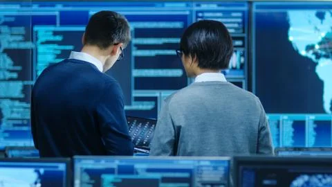 In the System Control Room IT Specialist and Project Engineer Have Discussion Stock Photos