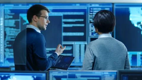 In the System Control Room IT Specialist and Project Engineer Have Discussion Stock Photos