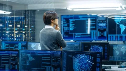 In the System Control Room Technical Operator Stands and Monitors Various Act Foto stock