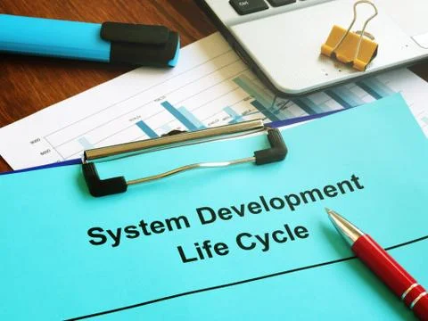 System Development Life Cycle SDLC papers and clipboard. Stock Photos