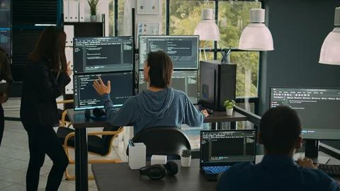 System engineer checking code on multiple monitors and working with app 写真素材