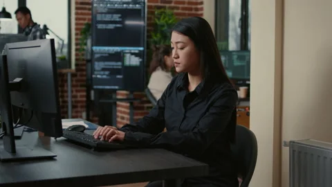 System engineer focused on writing code sitting at desk in software development Stock Footage 168244441