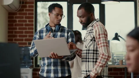System engineers talking about algorithms holding laptop and standing in the Stock Footage 168249850
