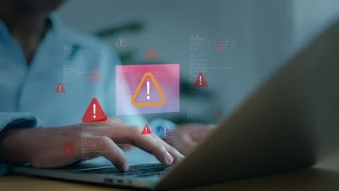 System failure or cyber attack concept with warning icons on laptop keyboar.. Stock Photos
