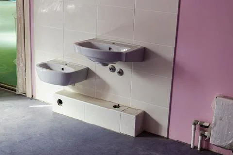 A system of numerous sinks installed in a public toilet. Stockfoto's