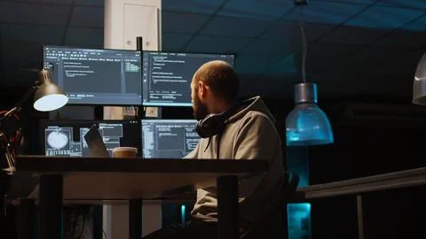 System programmer typing source code on laptop and multiple monitors 스톡 사진