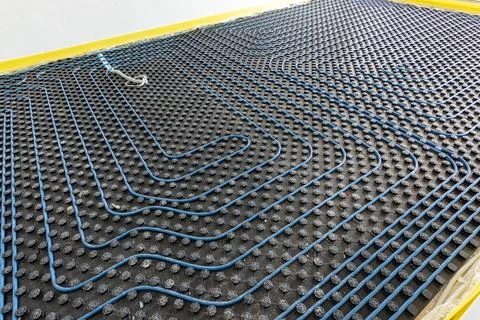 System of underfloor heating. Installation of a heat flooring system. Moder.. Stock Photos
