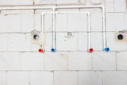 System of white plastic pipes installed in the wall for water supply Stock Photos