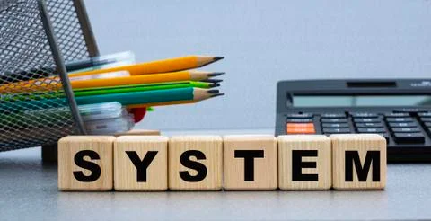 SYSTEM - words on a white sheet of paper with clamps on the background of a c Stock Photos