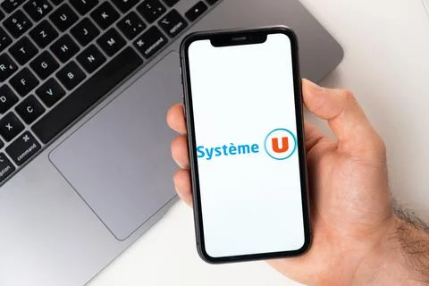 Systeme U mobile application on the smartphone screen. A mobile phone in a man Stock Photos