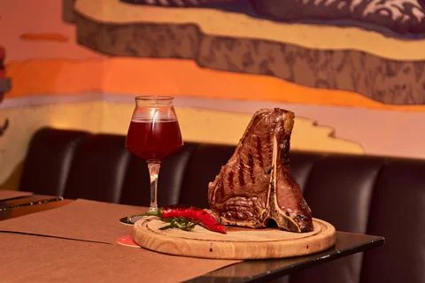T bone Beef Grilled steak meat with rosemary branch, pepper, salt and glass o Stock Photos