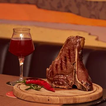 T bone Beef Grilled steak meat with rosemary branch, pepper, salt and glass o Stock Photos