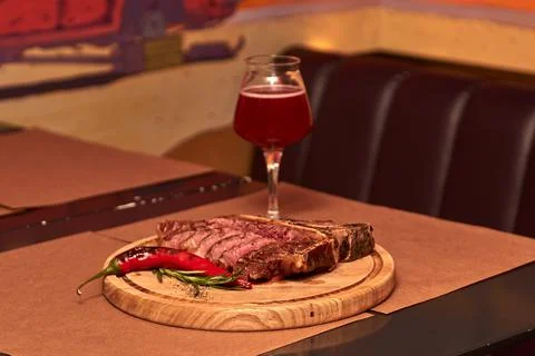 T bone Beef Grilled steak meat with rosemary branch, pepper, salt and glass o Stock Photos