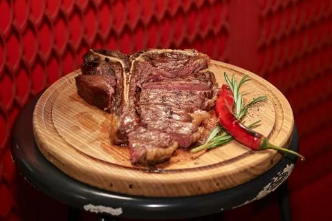T bone Beef Grilled steak meat with rosemary branch, pepper, salt and glass o Stock Photos