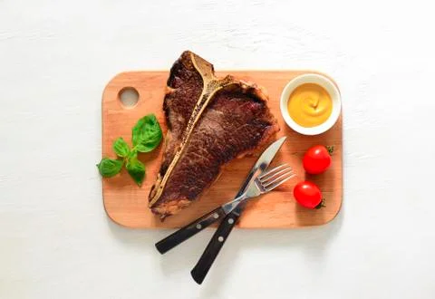 T-bone beef stake served on a cutting board Stock Photos