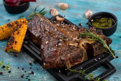 T-bone beef stake served on a cutting board, view from above Stock Photos