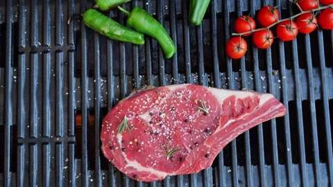 T bone beef steak on grill grate, flame. Close up. Top view Video stock 255826059