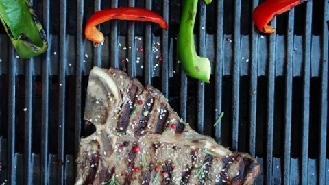 T- bone beef steak grill with vegetables on a cast iron barbecue. Top view Stock Footage 266822989