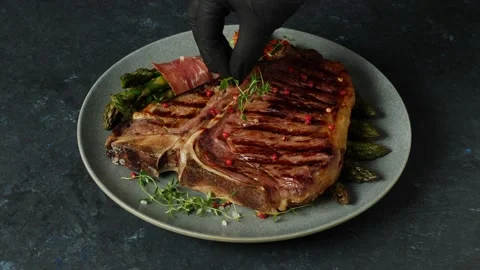 T bone beef steak, grilled. Presentation of the dish.  The cook is decorating Stock Footage 155154611