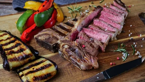T- bone beef steak grilled sliced with grilled vegetables rotate wooden board Stock Footage 266126411