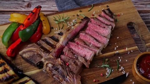 T- bone beef steak grilled sliced with grilled vegetables rotate wooden board Stock Footage 266823019
