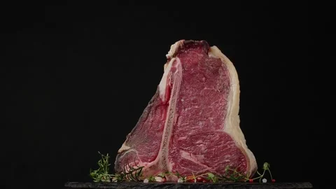 T bone. Raw beef steak. Presentation of the dish. Rotation. Black background. Stock Footage 155152187