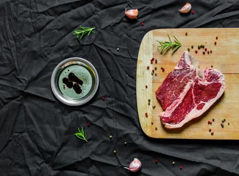 T bone steak of beef meat against black background Stock Photos