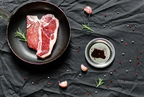 T bone steak of beef meat against black background Stock Photos