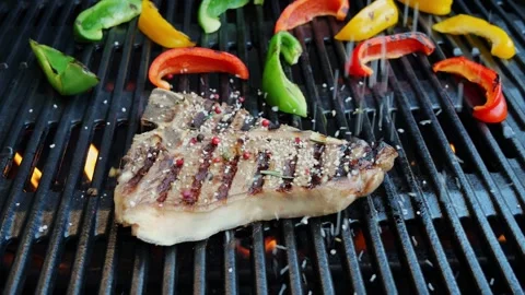 T- bone steak grill on cast iron barbecue sprinkle  spices. Slow motion Video stock 266126378