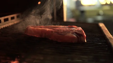 T-bone steak. A large piece of marble beef steaming on a hot grill Stock Footage 107674770