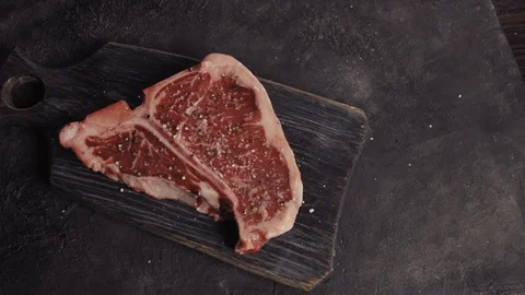 T-bone steak lies on a black board Stock Footage 113081667